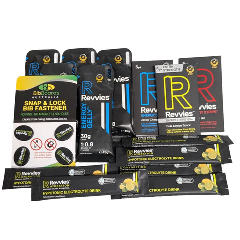 A collection of Revvies sports nutrition products, including energy gels, a snap & lock bib fastener, and electrolyte drinks, arranged on a plain white background.